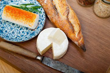 Image showing French cheese and fresh  baguette on a wood cutter