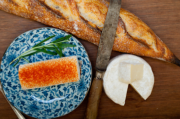 Image showing French cheese and fresh  baguette on a wood cutter