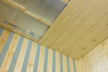 Image showing finishing of the ceiling insulated with foamed polyethylene with wooden clapboard during the construction of a country house