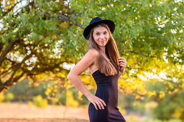 Image showing Portrait of a beautiful girl on a background of blurry green foliage