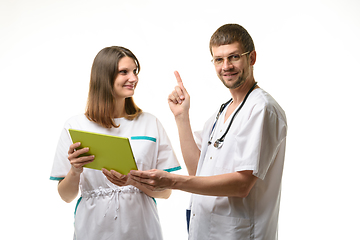 Image showing Two doctors discuss the test results, one of them happily threw up a finger