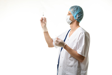 Image showing Surgeon holds a syringe in his hands and releases air bubbles from it, isolated on white background