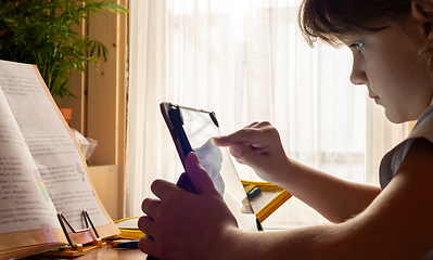 Image showing Girl studying online at home using tablet computer