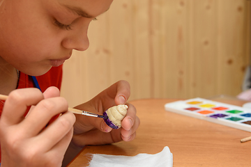 Image showing Girl at home paints figures from salt dough