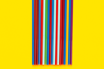 Image showing On a yellow background in the middle there are multi-colored cocktail tubes