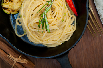 Image showing italian spaghetti pasta with zucchini sauce on iron skillet