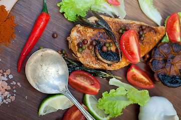 Image showing wood fired hoven cooked chicken breast on wood board 