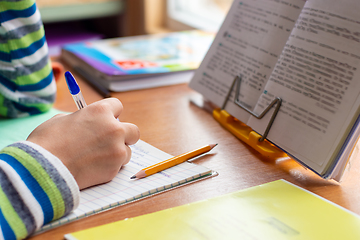 Image showing Close-up view of the hands of a schoolboy doing homework