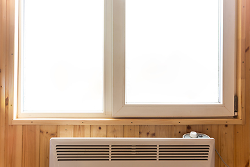 Image showing Plastic window installed in a country house, under the window there is an electric heating radiator