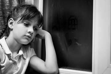 Image showing Girl draws figures of little men on a fogged window