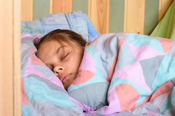 Image showing Teenage girl covered with a blanket sweetly sleeping in the early morning