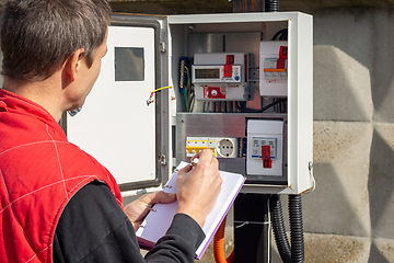 Image showing An electrician takes control readings of electricity meters