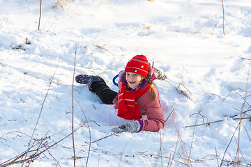 Image showing The girl rolled down the hill and happily looked into the frame