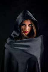 Image showing Portrait of a girl in a silk black cloak