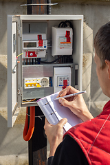 Image showing The gardener takes control readings of electricity meters