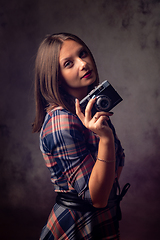 Image showing Girl photographer with retro camera, studio photography on gray background