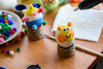 Image showing Painted easter egg with glued eyes stands on the table