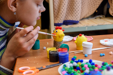 Image showing The girl paints crafts from eggs for the Easter holiday