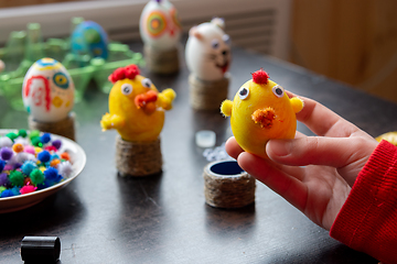 Image showing The child made a figurine of a chicken from an egg and shows it into the frame, in the background other figures