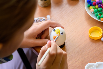 Image showing Close-up of hands of a child painting Easter eggs