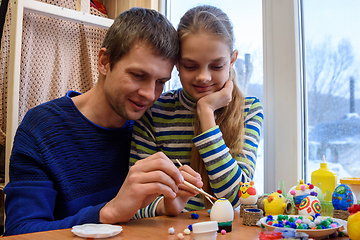 Image showing Father shows the girl how interesting it is to paint Easter eggs