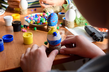 Image showing The child\'s hands are carefully holding toys from eggs for the Easter holiday