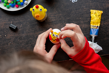 Image showing Girl making figurines from eggs, top view