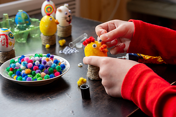 Image showing A child makes a gift egg for the Easter holiday