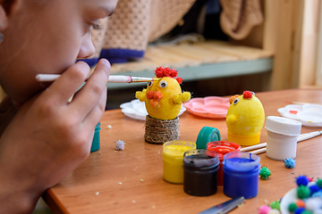 Image showing Girl gently paints Easter eggs with a brush and paints