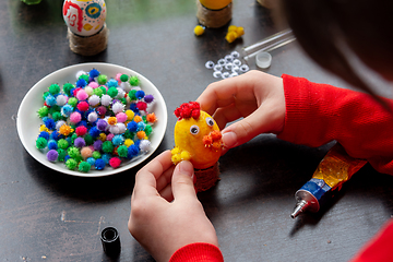 Image showing A girl glues wings to a chicken figurine made from an egg