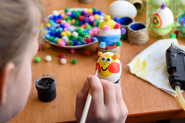 Image showing Girl beautifully paints Easter eggs