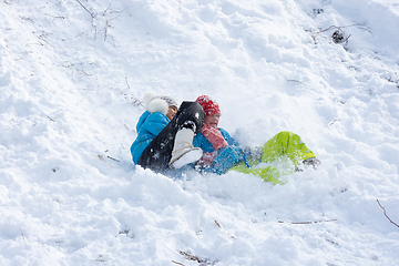 Image showing Two girls slide down a slide into a snowdrift