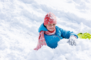 Image showing The girl who rolled down the hill has all her face in the snow, the girl looks funny into the frame
