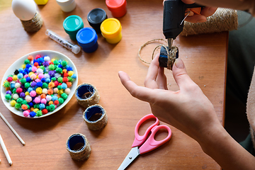 Image showing The girl\'s hands make crafts with a rut pistol