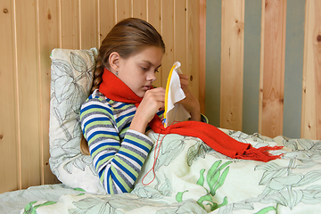 Image showing Sick girl lying in bed doing embroidery on the hoop