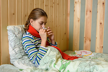 Image showing Sick girl drinking tea while sitting in bed