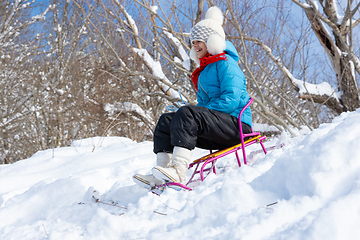 Image showing Girl sledding downhill in winter