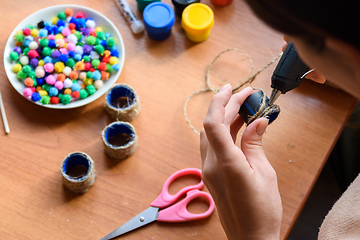 Image showing Girl\'s hands decorate elements with a glue gun