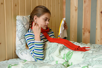 Image showing Sick girl lying in bed is embroidering on the hoop