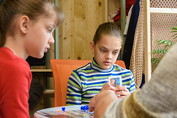 Image showing An adult explains to children how to play a board game