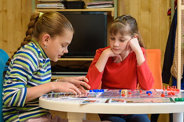 Image showing A girl explains to another girl how to play a board game