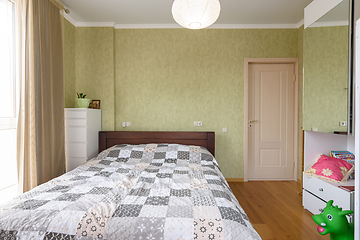 Image showing Bedroom interior with a large double bed and a wardrobe with a mirrored door