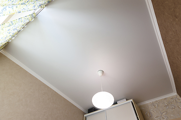 Image showing Stretch white matte ceiling close-up with a chandelier in the interior of a rectangular room