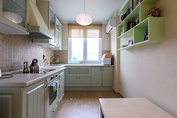 Image showing The interior of a light ordinary kitchen with a spacious kitchen set