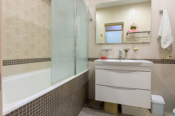 Image showing Bathroom interior, the bathroom is separated from the washbasin by a glass partition