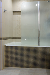 Image showing The bathroom is separated from the bathroom by a glass partition, the partition door is closed