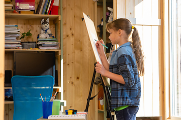 Image showing A ten-year-old girl draws on an easel at home