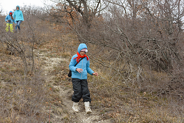 Image showing A girl runs down the path from the mountain, in the background a girl with another girl gently descend from the mountain