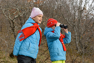 Image showing Girlfriend tells another girlfriend what she saw through binoculars