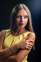 Image showing Portrait of a beautiful girl in a yellow dress on a black background